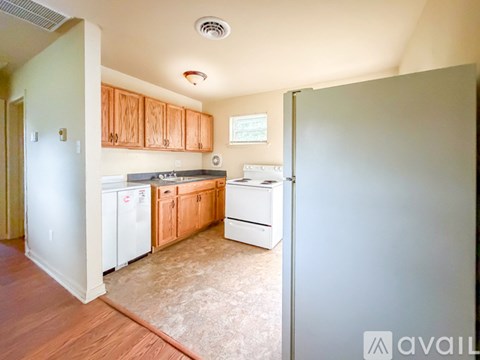 A kitchen with white appliances and wooden cabinets.
