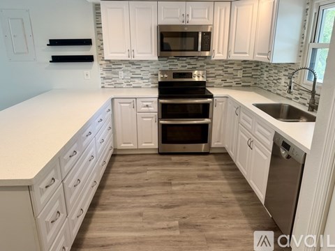 A kitchen with white cabinets and a black stove top oven.