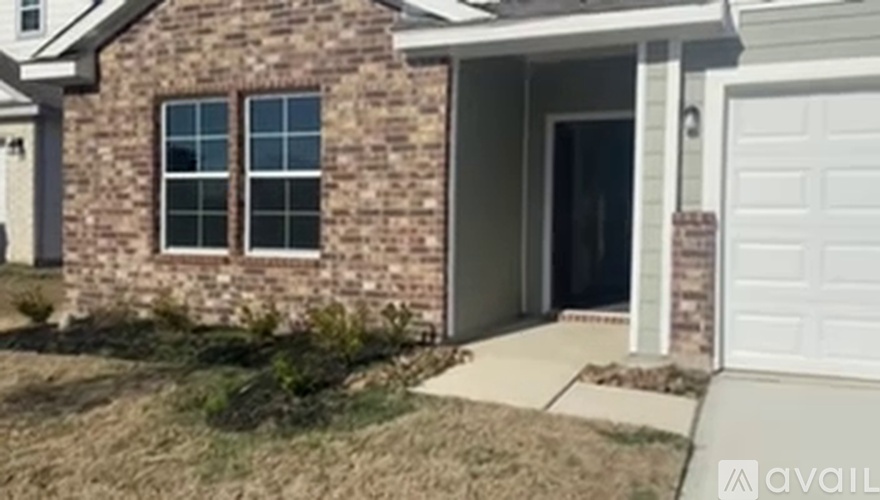 A house with a white garage door and a brick exterior.