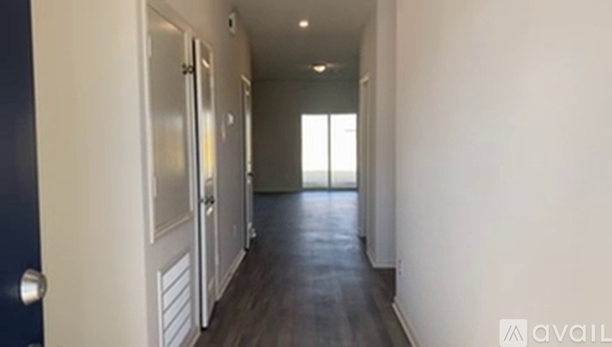 A hallway with a blue door and white walls.