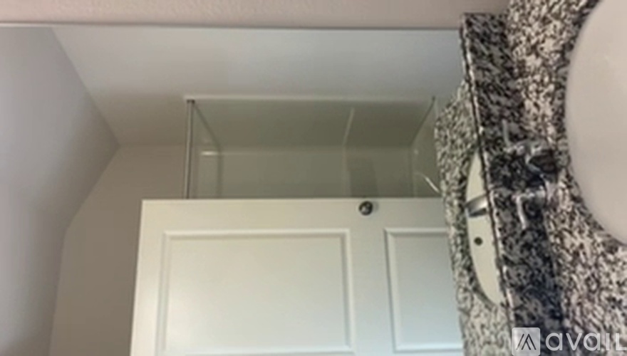 A white door is in a room with a ceiling fan.