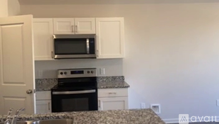 A kitchen with white cabinets and a granite countertop.