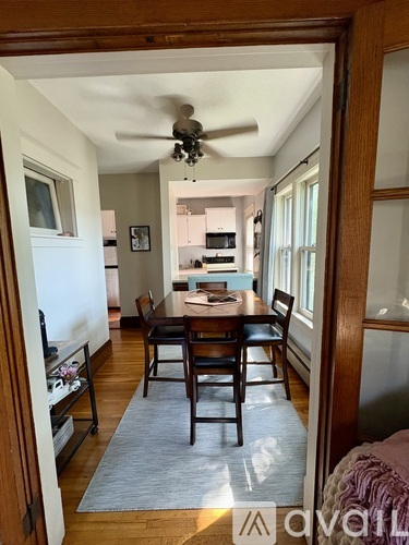 A dining room with a table and chairs is visible through an open door.