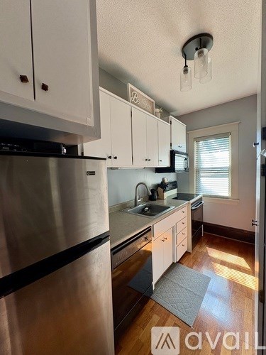 A kitchen with white cabinets and a stainless steel refrigerator.