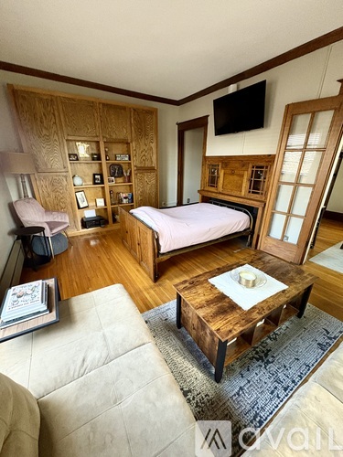 A bedroom with a bed, a couch, and a coffee table.
