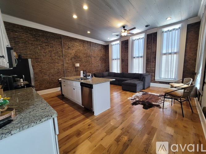 A kitchen with a refrigerator, a stove, and a counter with a marble top.
