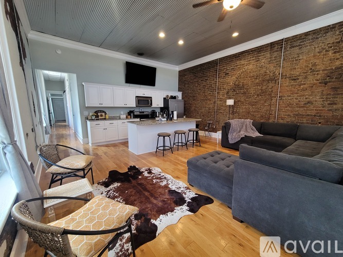 A living room with a grey couch and a wooden floor.