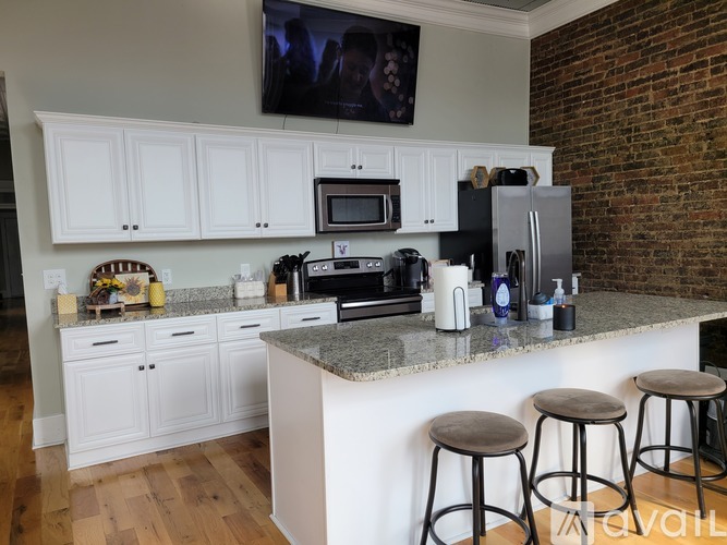 A kitchen with white cabinets and a granite countertop.