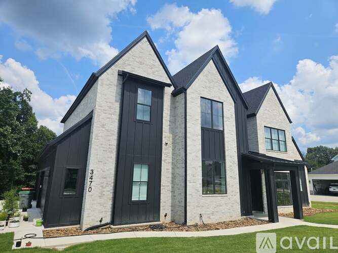 A modern house with a black and white exterior is for sale.