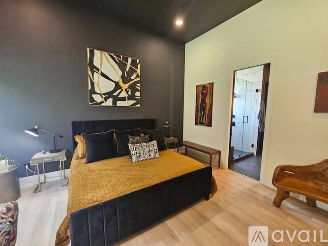 A bedroom with a large bed and a painting on the wall.