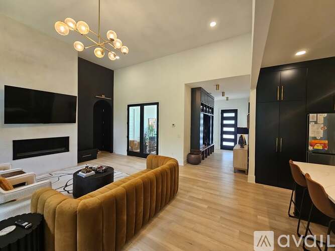 A modern living room with a brown sofa and a fireplace.
