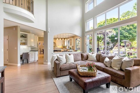 A living room with a brown couch and a basket of flowers on it.