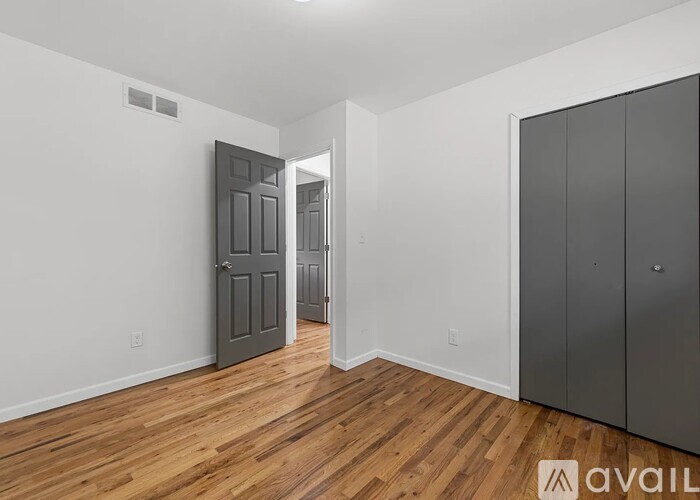 A room with wooden floors and a grey door.
