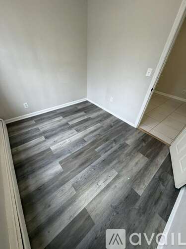 A room with wooden flooring and a white door.