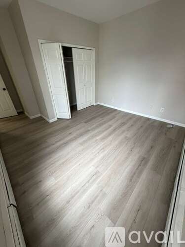 A room with a wooden floor and a white door.