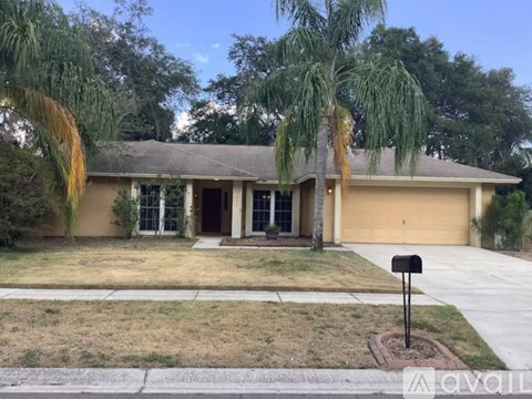 A house with a brown roof and a driveway in front.