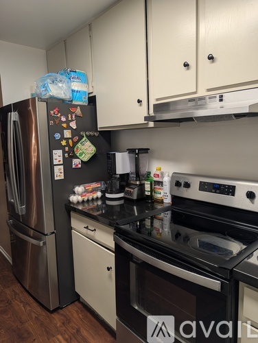 A kitchen with a stainless steel refrigerator, oven, and cabinets.