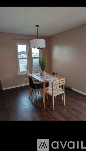A dining room with a wooden table and chairs.