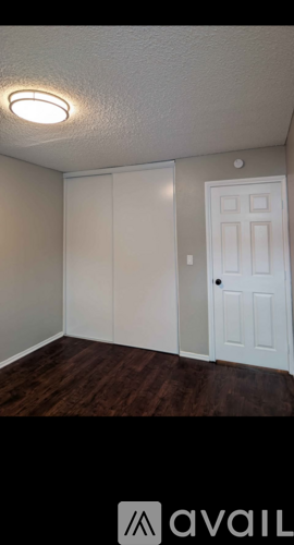 A room with a white door and a light on the ceiling.