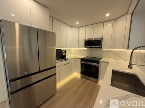 A modern kitchen with stainless steel appliances and white cabinetry.