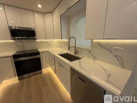 A modern kitchen with a stainless steel oven and a marble countertop.
