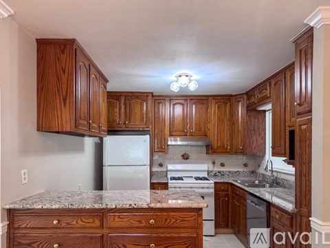 A kitchen with wooden cabinets and granite countertops.