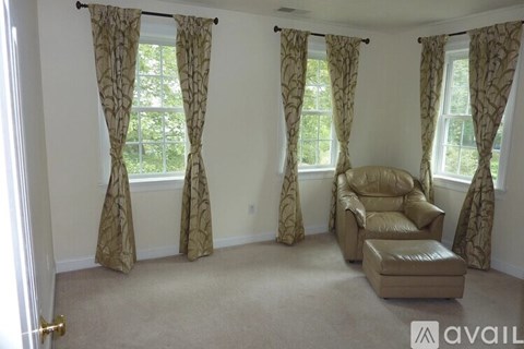 A living room with a beige sofa and matching ottoman.