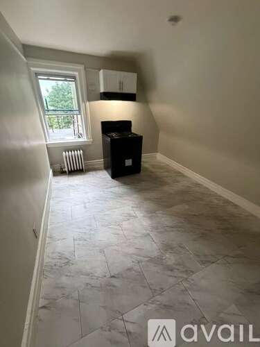 A room with a marble floor and a window with a view of trees.