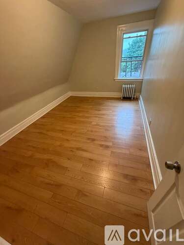 A room with wooden flooring and a window.