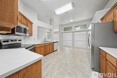 A kitchen with wooden cabinets and a white countertop.