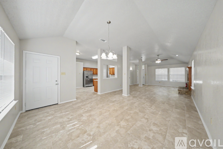 A spacious room with a tiled floor and white walls, currently under renovation.