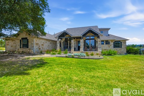 A house with a stone exterior and a large front yard.