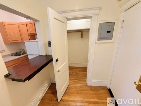 A kitchen with white cabinets and a black countertop.