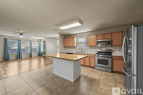 A kitchen with wooden cabinets and a white island.