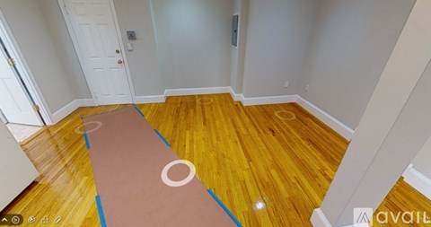 A room with wooden flooring and a white door.