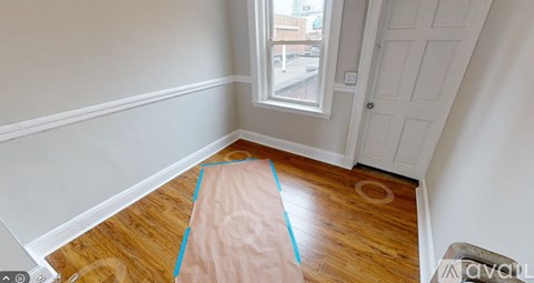 A room with a wooden floor and a white door.