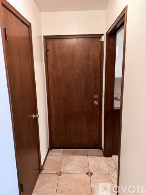 A room with a brown door and a tiled floor.