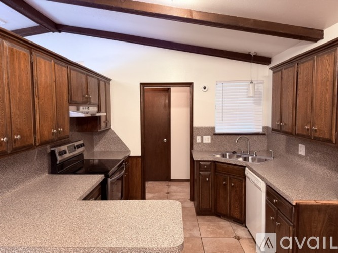 A kitchen with wooden cabinets and a black countertop.