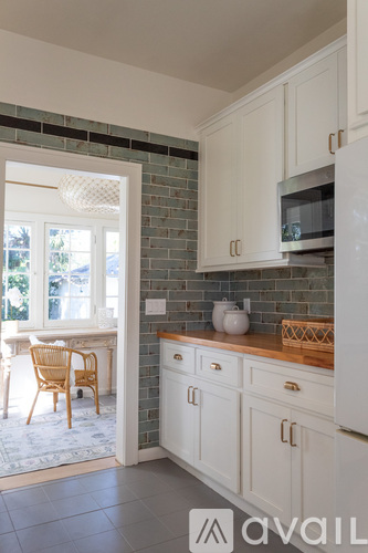 A kitchen with white cabinets and a white fridge.