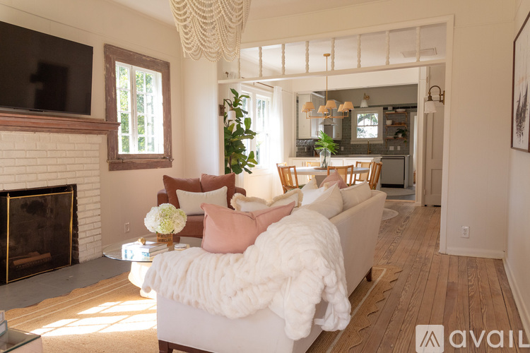 A living room with a white couch and a fireplace.