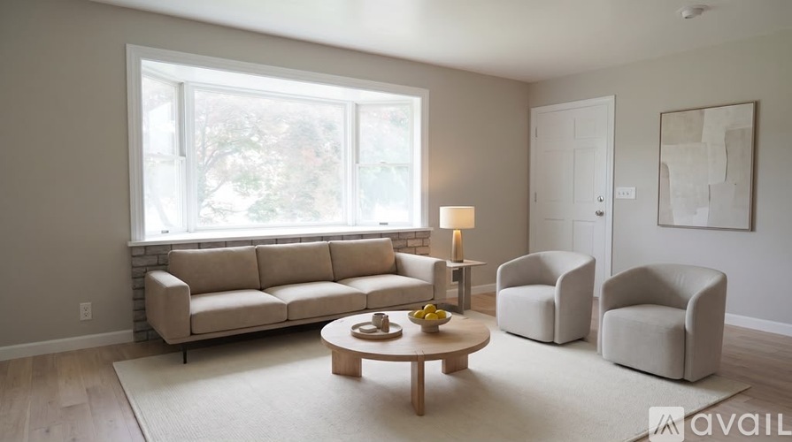A living room with a couch, two chairs, and a coffee table.