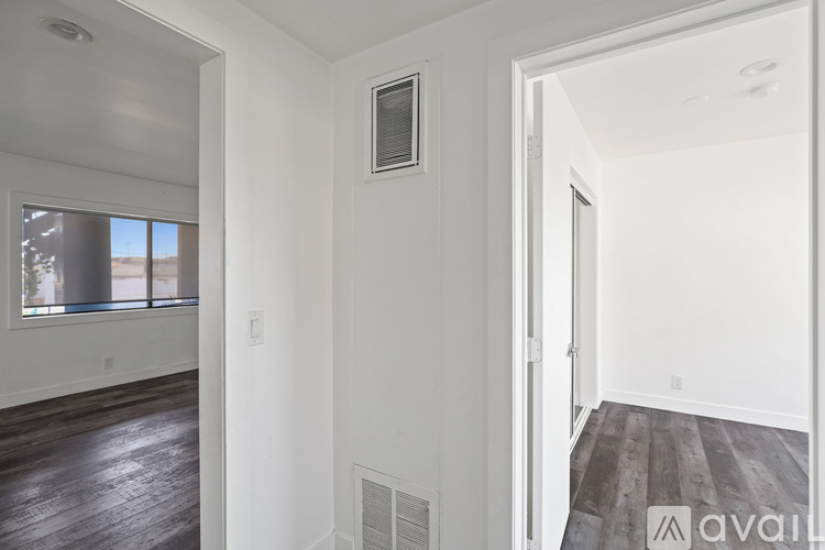 A room with white walls and a window with a view of a building outside.