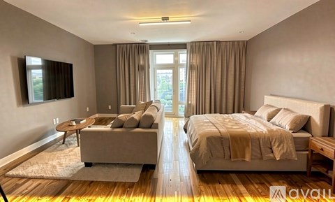 A bedroom with a large bed and a couch.
