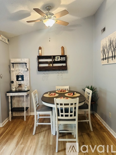 A dining room with a table set for two and a shelf above it.