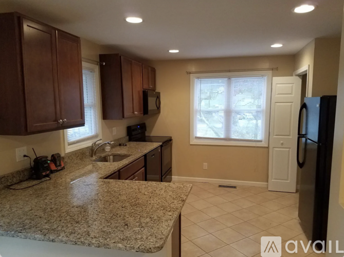 A kitchen with granite countertops and wooden cabinets.