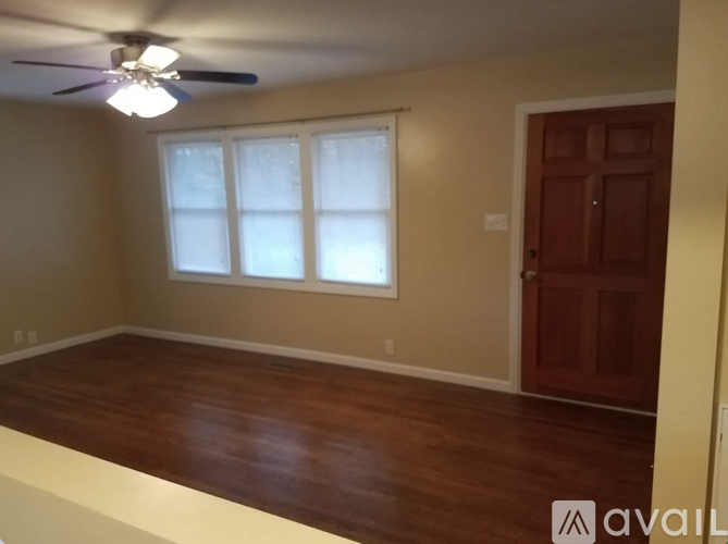 A room with a ceiling fan and a door.