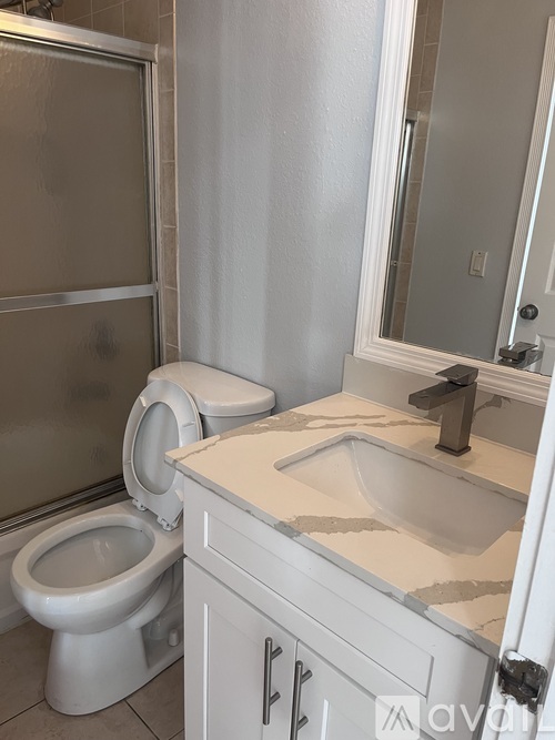 A white toilet sits next to a sink in a bathroom.