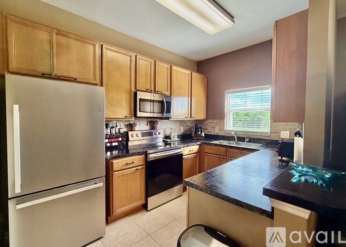 A kitchen with wooden cabinets and a black countertop.