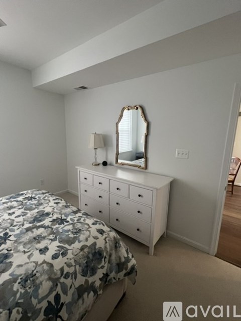 A bedroom with a bed, dresser, and mirror.