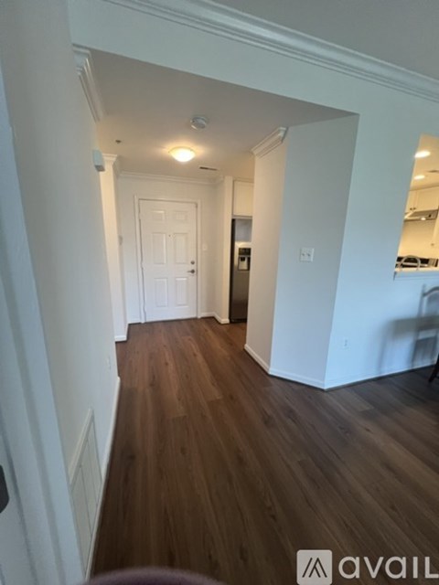 A hallway with wood floors and white walls.